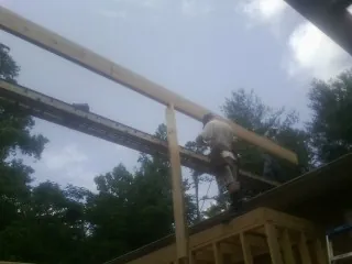 Carpenter setting a ridge beam over a new addition frame — Ice Dam Removal by Roofing Brothers in Ridgeville