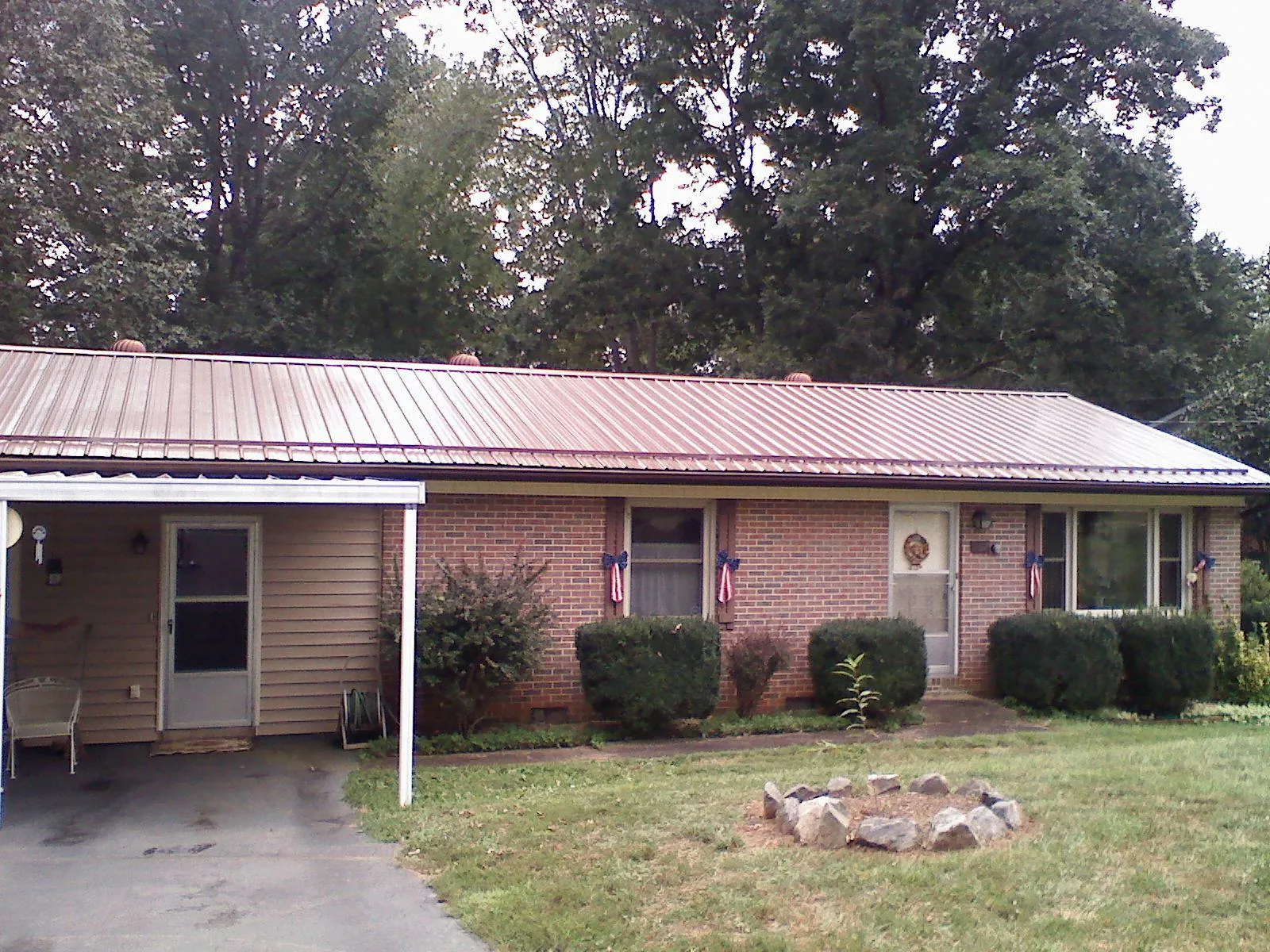 Bronze metal roof and carport on a brick ranch home — Roof Repair work by our crew in Ridgeville